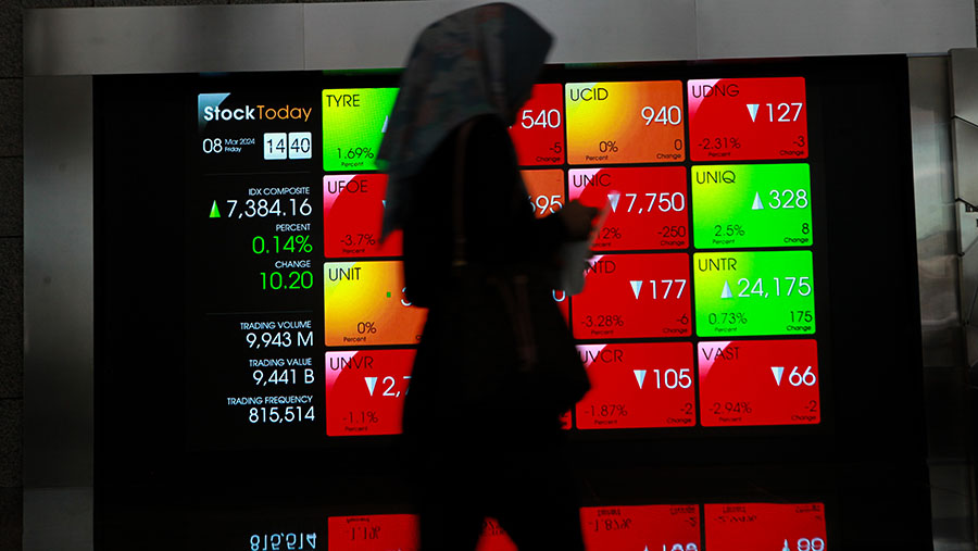 Kayawan melintasi layar pergerakan perdagangan saham (IHSG) di Bursa Efek Indonesia (BEI), Jumat (8/4/2024). (Bloomberg Technoz/Andrean Kristianto)