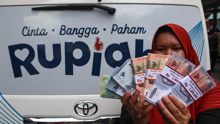 Warga menunjukkan uang yang sudah ditukarkan di Pasar Tebet, Jakarta, Selasa (19/3/2024). (Bloomberg Technoz/Andrean Kristianto)