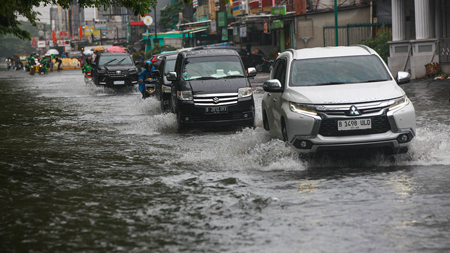 Kendaraan melintas saat banjir di kawasan Kelapa Gading, Jakarta Utara, Jumat (22/3/2024). (Bloomberg Technoz/Andrean Kristianto)