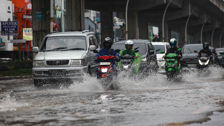 Kendaraan melintas saat banjir di kawasan Kelapa Gading, Jakarta Utara, Jumat (22/3/2024). (Bloomberg Technoz/Andrean Kristianto)