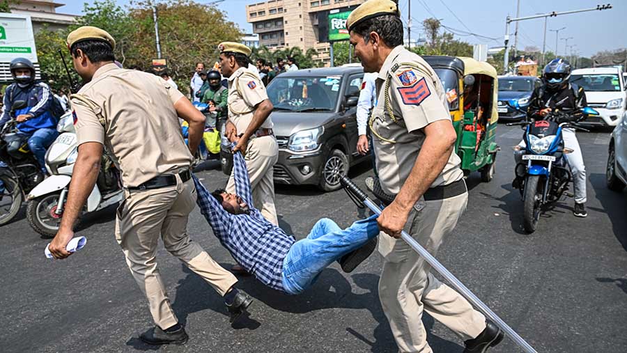 Polisi mengusir seorang demonstran saat protes terhadap penangkapan Arvind Kejriwal di Delhi, India, Jumat (22/3/2024). (Prakash Singh/Bloomberg)
