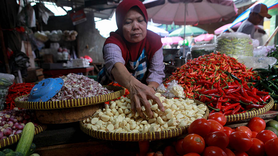 Pedagang merapihkan bawang putihdi Pasar Kebayoran Lama, Jakarta, Senin (25/3/2024). (Bloomberg Technoz/Andrean Kristianto)