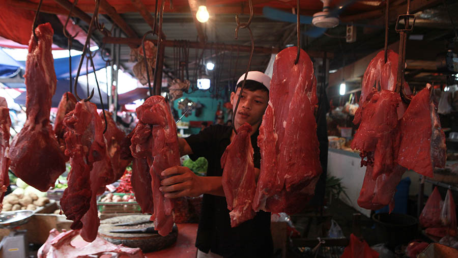 Pedagang memotong daging sapi di Pasar Kebayoran Lama, Jakarta, Senin (25/3/2024). (Bloomberg Technoz/Andrean Kristianto)