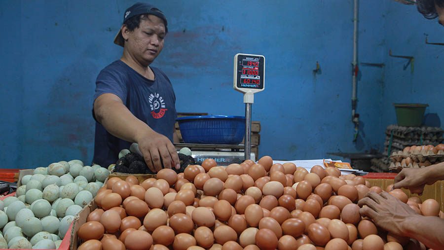 Pedagang merapihkan telur ayam di Pasar Kebayoran Lama, Jakarta, Senin (25/3/2024). (Bloomberg Technoz/Andrean Kristianto)