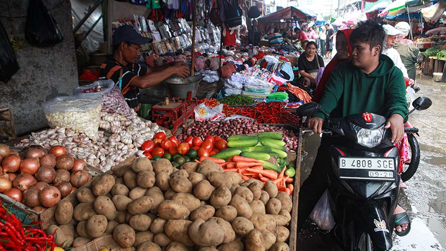 Pedagang melayani pembeli cabai di Pasar Kebayoran Lama, Jakarta, Senin (25/3/2024). (Bloomberg Technoz/Andrean Kristianto)
