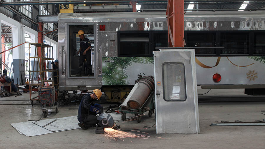 Petugas melakukan perawatan bagian kereta api di Balai Yasa Manggarai, Jakarta, Selasa (26/3/2024). (Bloomberg Technoz/Andrean Kristianto)