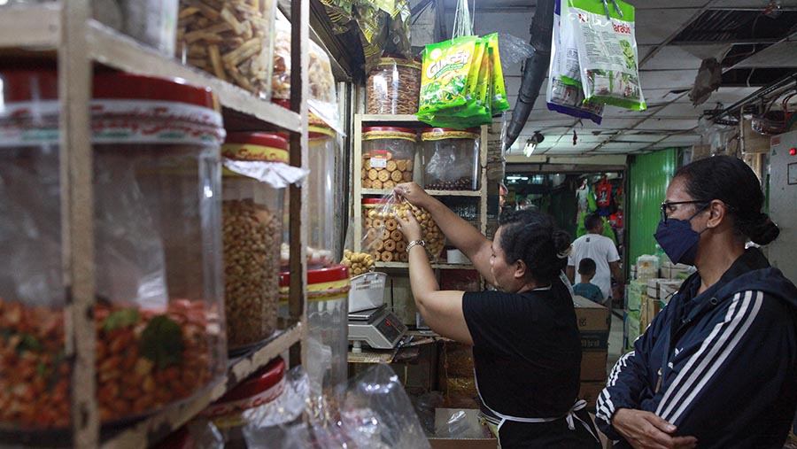 Pembeli berbelanja kue kering di Pasar Jatinegara, Jakarta, Kamis (28/3/2024). (Bloomberg Technoz/Andrean Kristianto)