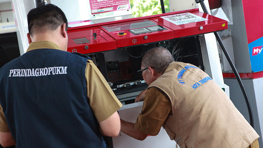 Selain melakukan pengukuran ulang takaran BBM, petugas juga memeriksa segel mesin penampung BBM. (Bloomberg Technoz/Andrean Kristianto)