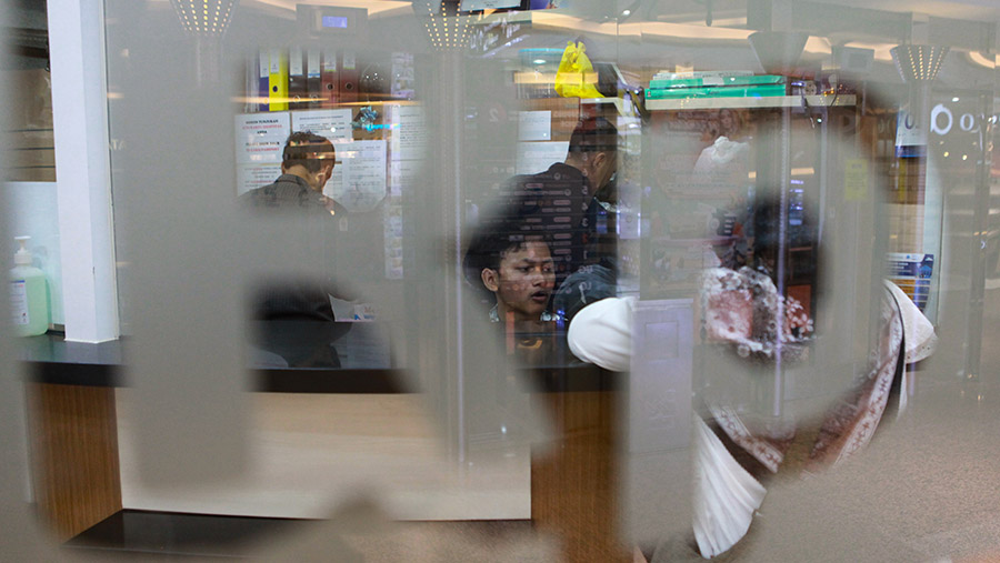 Petugas melayani penukaran uang asing di salah satu gerai penukaran uang asing di Jakarta, Senin (1/4/2024). (Bloomberg Technoz/Andrean Kristianto)