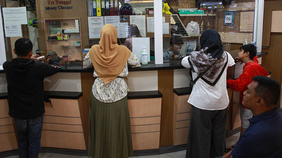 Pengunjung menukarkan uang asing di salah satu gerai penukaran uang asing di Jakarta, Senin (1/4/2024). (Bloomberg Technoz/Andrean Kristianto)
