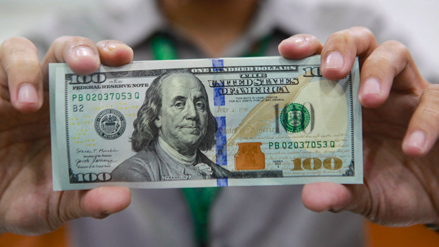Pekerja memperlihatkan dolar AS di salah satu gerai penukaran uang asing di Jakarta, Senin (1/4/2024). (Bloomberg Technoz/Andrean Kristianto)
