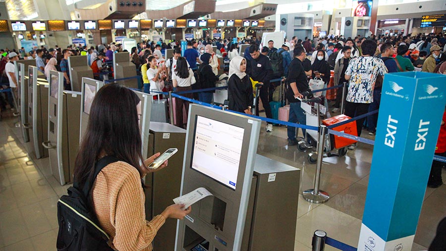 Penumpang pesawat melakukan check in mandiri di Terminal 3, Bandara Soetta, Sabtu (6/4/2024). (Bloomberg Technoz/Andrean Kristianto)