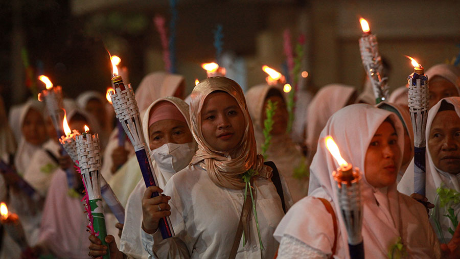 Peserta mengikuti pawai obor malam takbiran di Masjid Istiqlal, Jakarta, Selasa (9/4/2024). (Bloomberg Technoz/Andrean Kristianto)
