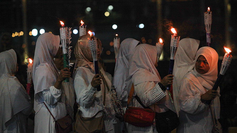 Peserta mengikuti pawai obor malam takbiran di Masjid Istiqlal, Jakarta, Selasa (9/4/2024). (Bloomberg Technoz/Andrean Kristianto)