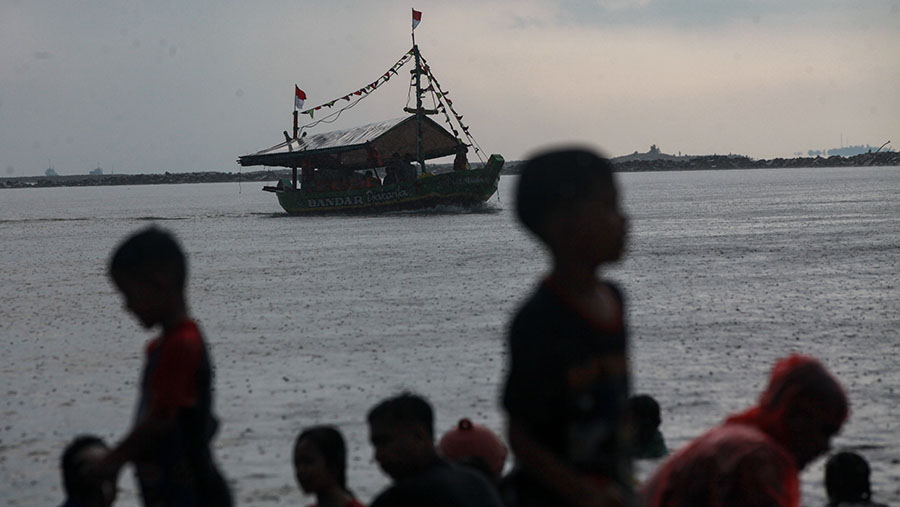 Pengunjung bermain di Pantai Lagoon Ancol, Jakarta, Jumat (12/4/2024). (Bloomberg Technoz/Andrean Kristianto)