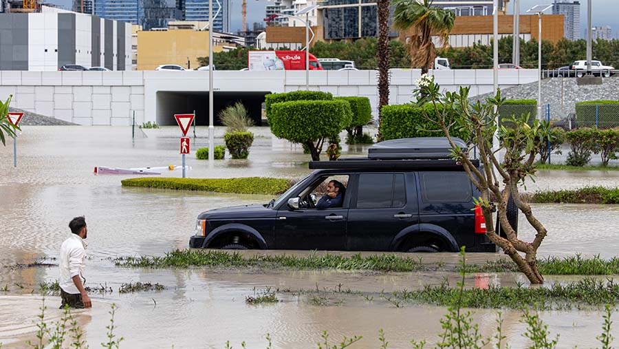 Kendaraan melewati banjir akibat hujan lebat di distrik Dubai Sports City di Dubai, UEA, Selasa (16/4/2024). (Christopher Pike/Bloomberg)