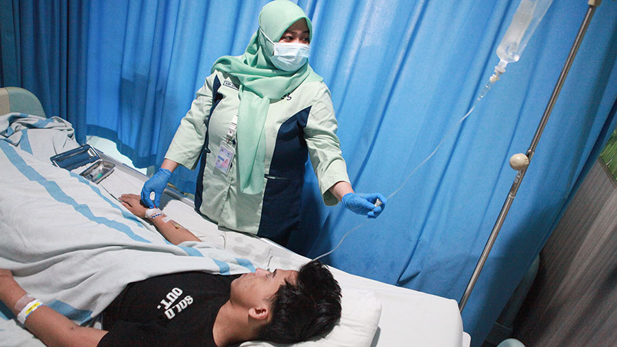 Petugas kesehatan melakukan perawatan pasien demam berdarah dengue (DBD) di RSUD Tamansari, Jumat (26/4/2024). (Bloomberg Technoz/Andrean Kristianto).
