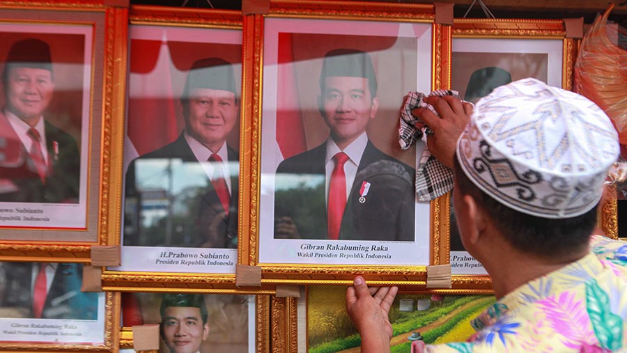 Pedagang menjajakan foto Prabowo-Gibran sebagai Presiden dan Wapres di kawasan Pasar Baru, Jumat (26/4/2024). (Bloomberg Technoz/Andrean Kristianto)