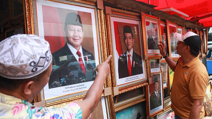 Pedagang menjajakan foto Prabowo-Gibran sebagai Presiden dan Wapres di kawasan Pasar Baru, Jumat (26/4/2024). (Bloomberg Technoz/Andrean Kristianto)