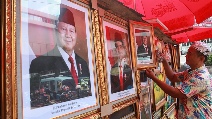 Pedagang menjajakan foto Prabowo-Gibran sebagai Presiden dan Wapres di kawasan Pasar Baru, Jumat (26/4/2024). (Bloomberg Technoz/Andrean Kristianto)