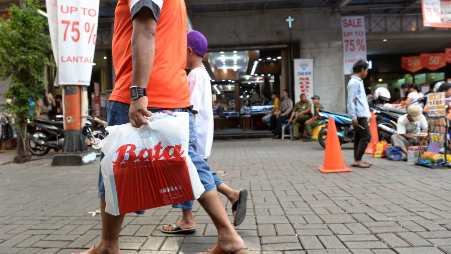 Konsumen membawa kantor belanja sepatu Bata di Jakarta./Bloomberg-Dimas Ardian