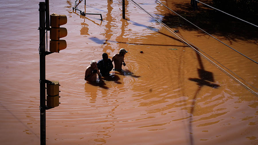 Warga melewati air banjir di Porto Alegre, negara bagian Rio Grande do Sul, Brasil, pada Senin (6/5/2024). (Carlos Macedo/Bloomberg)
