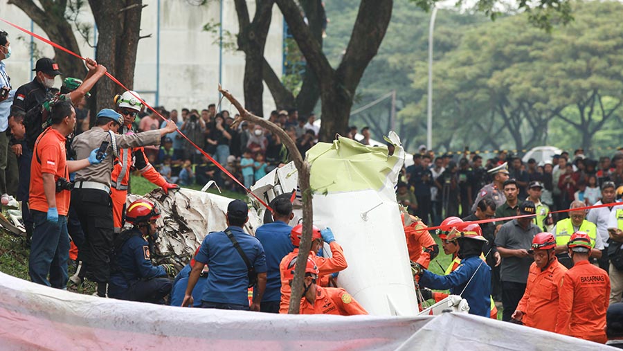 Petugas mengevakusi korban pesawat jatuh di BSD Serpong, Tangerang Selatan, Banten, Minggu (18/5/2024). (Bloomberg Technoz/Andrean Kristianto)