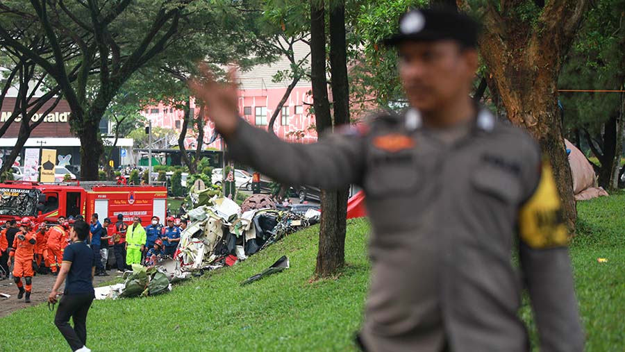 Petugas kepolisian berusaha menghalau warga yang berusaha mendekat lokasi kejadian,. (Bloomberg Technoz/Andrean Kristianto)