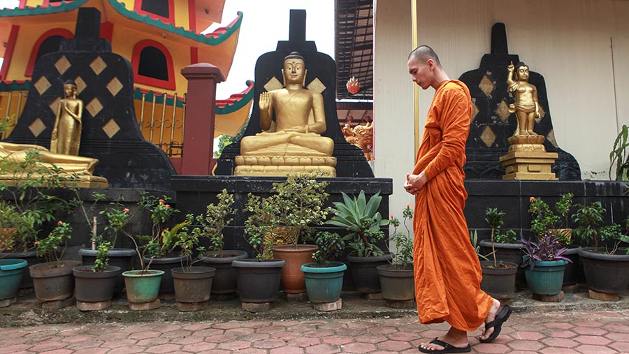 Samanera berjalan di Vihara Avalokitesvara Pondok Cabe, Rabu (22/5/2024). (Bloomberg Technoz/ Andreank Kristianto)
