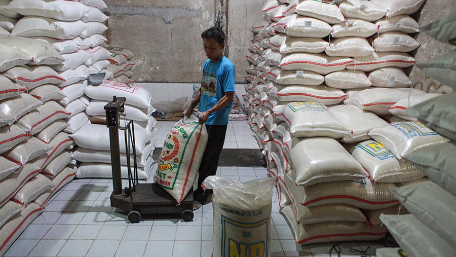 Pekerja menimbang karung beras di agen beras kawasan Pamulang, Rabu (22/5/2024). (Bloomberg Technoz/ Andrean Kristianto)