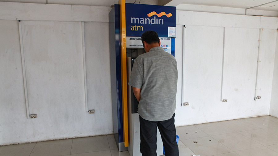 Warga transaksi di mesin ATM Bank di kawasan Ciputat, Tangerang Selatan, Senin (3/6/2024). (Bloomberg Technoz/Andrean Kristianto)
