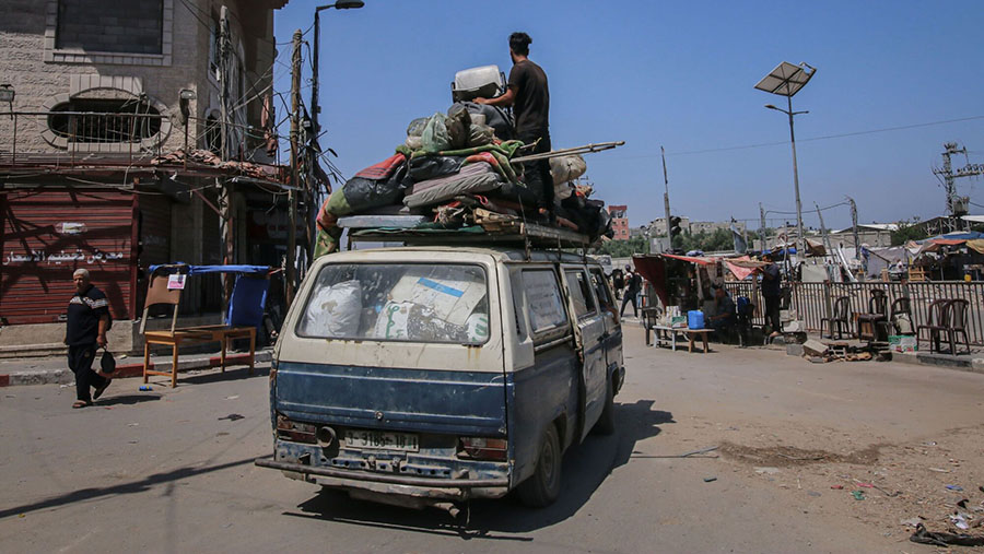 Warga Palestina membawa barang mereka saat meninggalkan kamp pengungsi Bureij, Gaza tengah, Rabu (5/6/2024). (Ahmad Salem/Bloomberg)