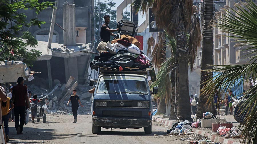 Warga Palestina membawa barang mereka di saat meninggalkan kamp pengungsi Bureij, Gaza tengah, Rabu (5/6/2024). (Ahmad Salem/Bloomberg)