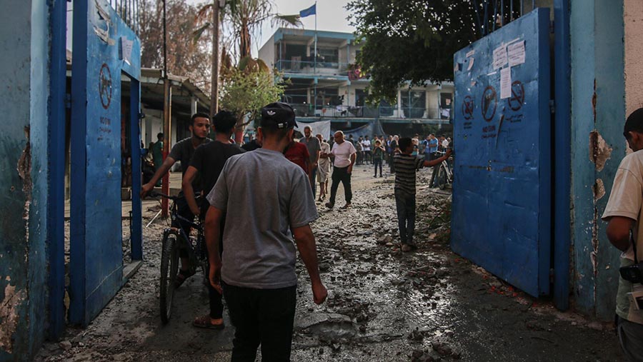 Warga Palestina melihat kerusakan sekolah yang dioperasikan oleh UNRWA usai serangan Israel di Gaza tengah, Kamis (6/6/2024). (Ahmad Salem/Bloomberg)
