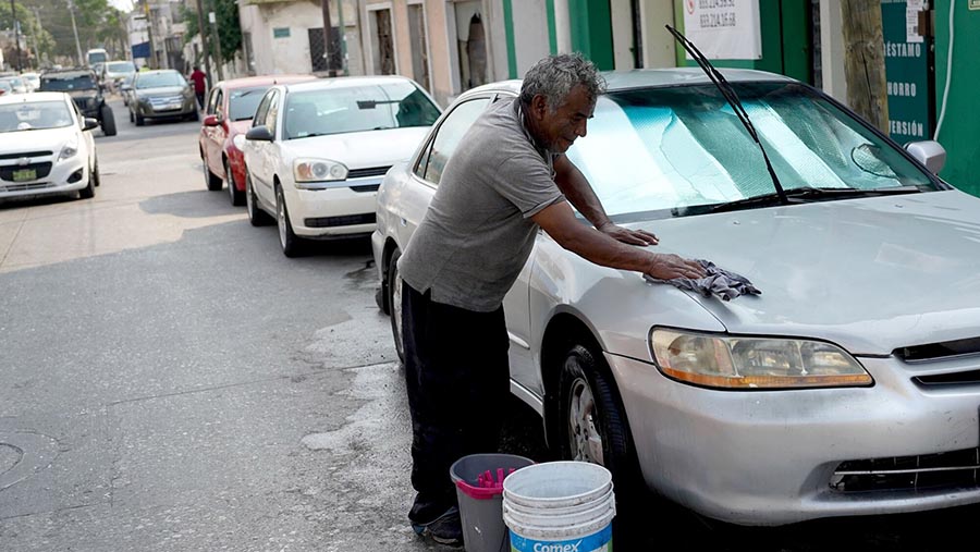 Seorang warga mencuci kendaraan di Tampico, Tamaulipas, Meksiko, Jumat (7/6/2024). (Mauricio Palos/Bloomberg)