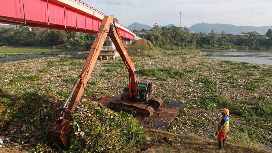 Alat berat membersihkan sampah di Sungai Citarum di Batujajar, Kab. Bandung, Jawa Barat, Kamis (13/6/2024). (Bloomberg Technoz/Andrean Kristianto)