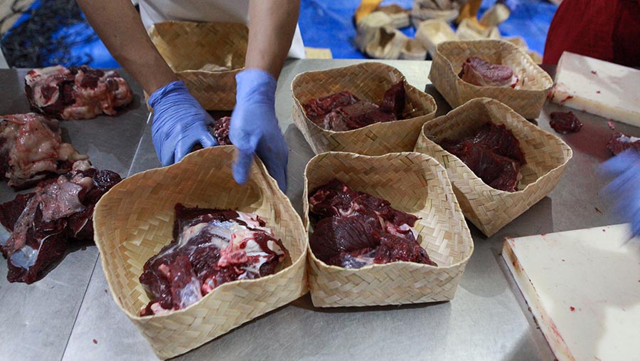 Pekerja mengemas daging hewan kurban yang disembelih di RPH Perumda Dharma Jaya, Jakarta, Senin (17/6/2024). (Bloomberg Technoz/Andrean Kristianto)