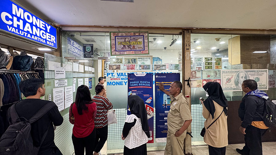 Warga antre menukarkan uang asing di gerai penukaran uang di ITC Kuningan, Jakarta, Jumat (21/6/2024). (Bloomberg Technoz/Andrean Kristianto)