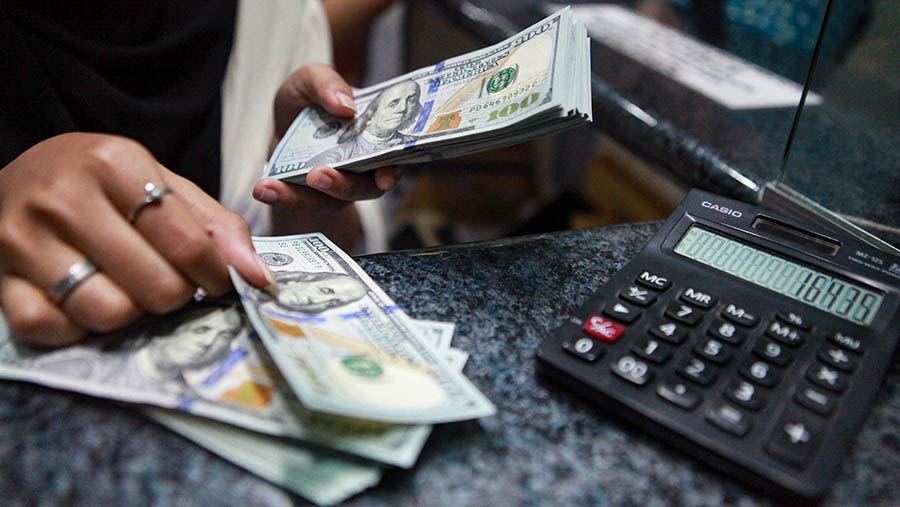 Karyawan merapihkan uang dolar AS di gerai penukaran uang di ITC Kuningan, Jakarta, Jumat (21/6/2024). (Bloomberg Technoz/Andrean Kristianto)