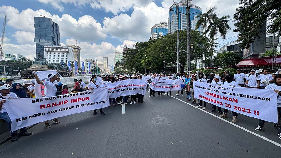 Ratusan buruh tekstil menggelar aksi demo di kawasan Patung Kuda, Jakarta, Kamis (27/6/2024). (Bloomberg Technoz/Andrean Kristianto)