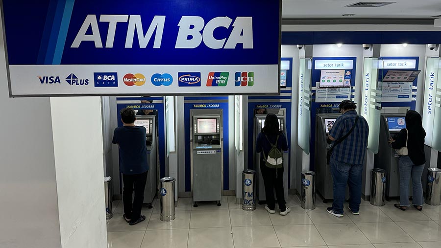 Warga bertansaksi di mesin ATM Bank BCA di Jakarta, Rabu (12/6/2024). (Bloomberg Technoz/Andrean Kristianto)