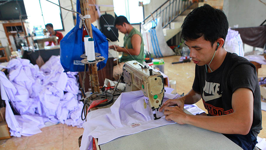 Pekerja konveksi menjahit bahan tekstil untuk dibuat seragam sekolah di Mampang, Jakarta, Kamis (4/7/2024). (Bloomberg Technoz/Andrean Kristianto)