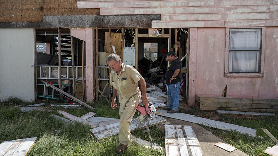 Warga di sekitar rumah yang rusak setelah Badai Beryl menerjang Sargent, Texas, AS, Senin (8/7/2024). (Eddie Seal/Bloomberg)