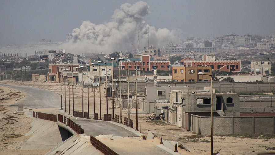 Asap mengepul di atas gedung-gedung menyusul serangan udara Israel di selatan Kota Gaza, Gaza, Rabu (10/7/2024). (Ahmad Salem/Bloomberg)