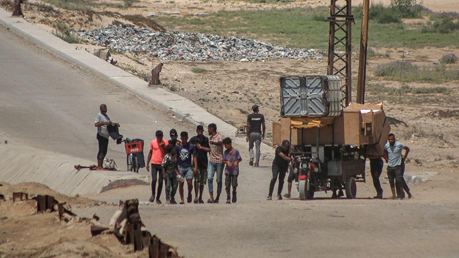 Warga Palestina mengungsi dari Kota Gaza berjalan di sepanjang koridor tentara Israel di Gaza tengah, Rabu (10/7/2024). (Ahmad Salem/Bloomberg)