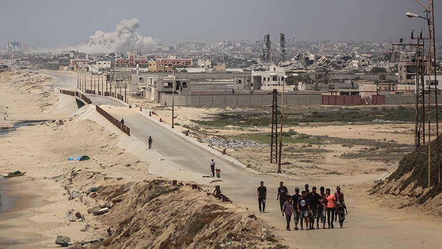 Asap mengepul di atas gedung-gedung menyusul serangan udara Israel di selatan Kota Gaza, Gaza, Rabu (10/7/2024). (Ahmad Salem/Bloomberg)
