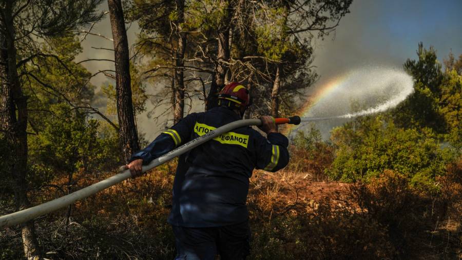 Petugas pemadam kebakaran bekerja untuk memadamkan api di dekat Stamata, Yunani pada 30 Juni. (Fotografer: Nick Paleologos/Bloomberg)