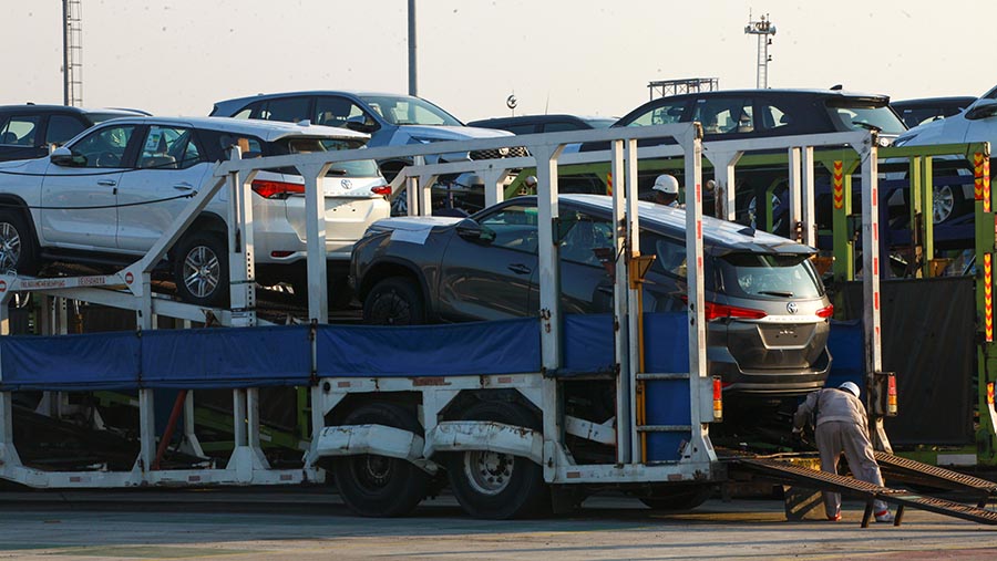 Petugas bongkar muat mobil Toyota Fortuner yang akan diekspor di IPCC Terminal Kendaraan, Jumat, (12/7/2024). (Bloomberg Technoz/Andrean Kristianto)