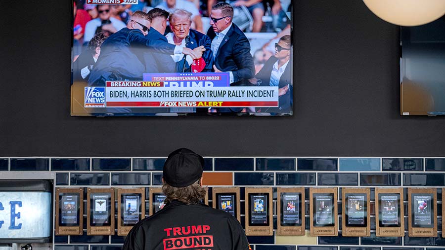 Monitor menampilkan berita dari kampanye mantan Presiden AS Donald Trump di Milwaukee, Wisconsin, AS, Sabtu (13/7/2024). (David Paul Morris/Bloomberg)