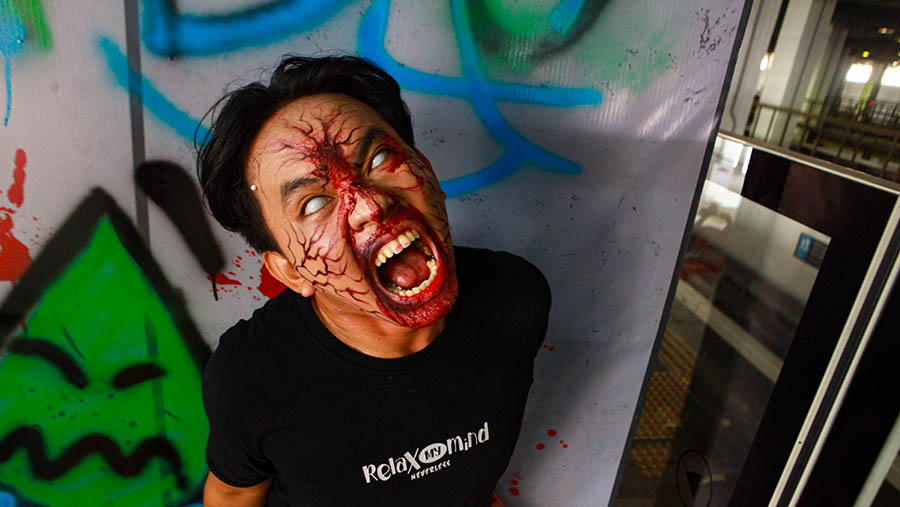 Aktor menakuti penumpang LRT Jakarta di Stasiun LRT Jakarta, Senin (15/7/2024). (Bloomberg Technoz/Andrean Kristianto)